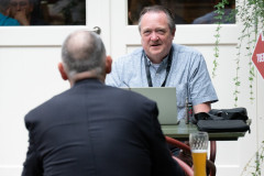 20250711 NK Venlo. Verslaggever Ron Puyn schrijft zijn rondeverslag. Op de rug Hans van Mulekom. (Foto KNSB/Schaakbond)