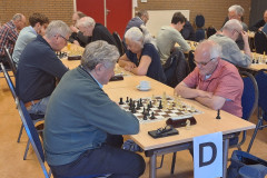 Nunhems schaaktoernooi 2025 Poule D: John Stikkelbroeck zit derde van links, schuin tegenover hem Peter Timmermans.