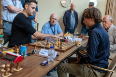 20250708 NK Schaken Venlo. Meeschrijvers Ad Burgmans en Bas van der Grinten bij de barragepartij Benjamin Bok tegen Liam Vrolijk. (Foto Harry Gielen)