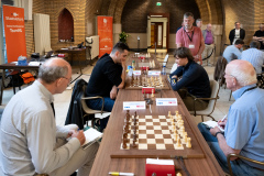 20250708 NK Schaken Venlo. Meeschrijvers Ad Burgmans en Bas van der Grinten bij de barragepartij Benjamin Bok tegen Liam Vrolijk. (Foto Frans Peeters)