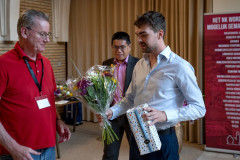 20250712 NK Venlo. Gerard in ’t Veld (links) geeft Jorden van Foreest een Venloos souvenir: Venloos Köpke. In het midden KNSB-directeur Dharma Tjiam. (Foto Frans Peeters)