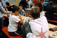 Open NK Rapid voor jeugdteams 200426 september 2004 te Mierlo.Ronde 4 tegen team  van Op Eigen Wieken Leiden. Tegenstandster Talitha Munnik. Spannend omdat Thijmen heel veel in tijd voor stond. Uiteindelijk toch remise (beiden koning over). Op de voorgrond David van Dongen